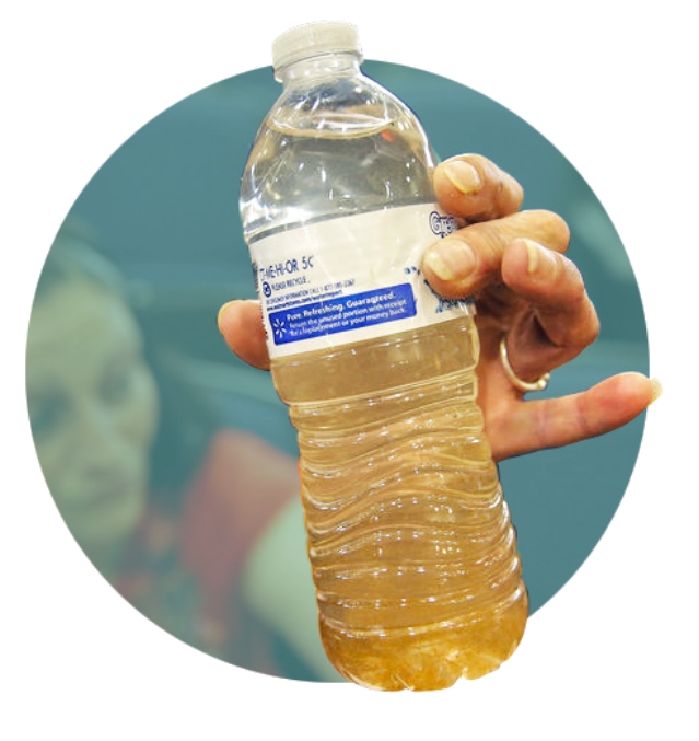 woman holding plastic bottle filled with contaminated water