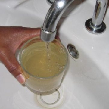 brown water - stock photo, glass being filled at tap